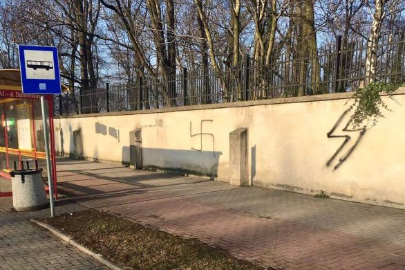 Une croix gammée et des graffitis nazis peints sur le mur d'un cimetière juif près d'Auschwitz